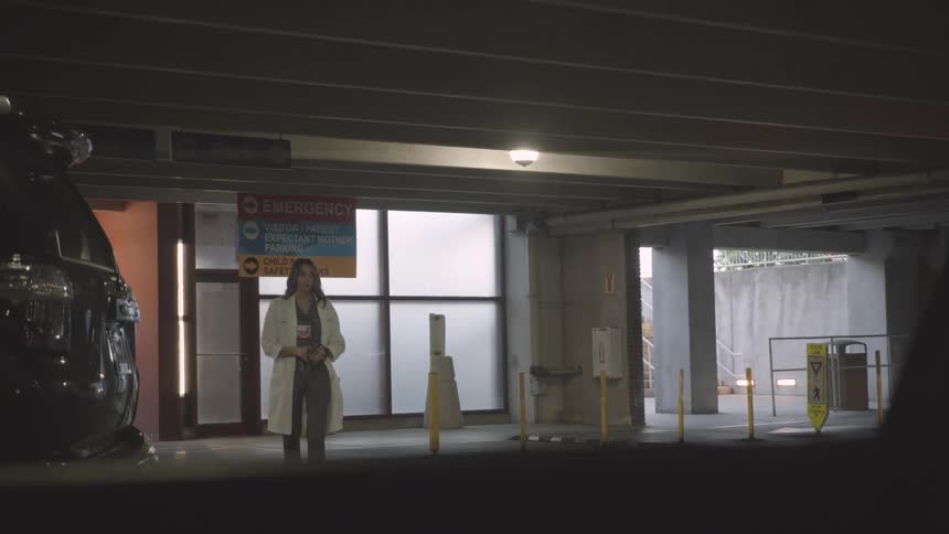 A doctor exits the hospital and heads into the parking garage