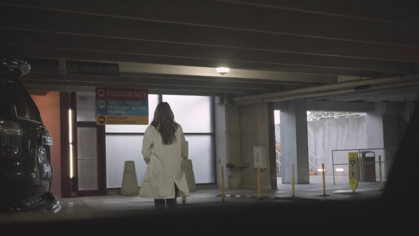 A doctor walks towards the hospital entrance