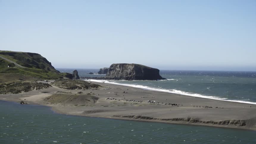 Waves come to shore on a sandy beach peninsula