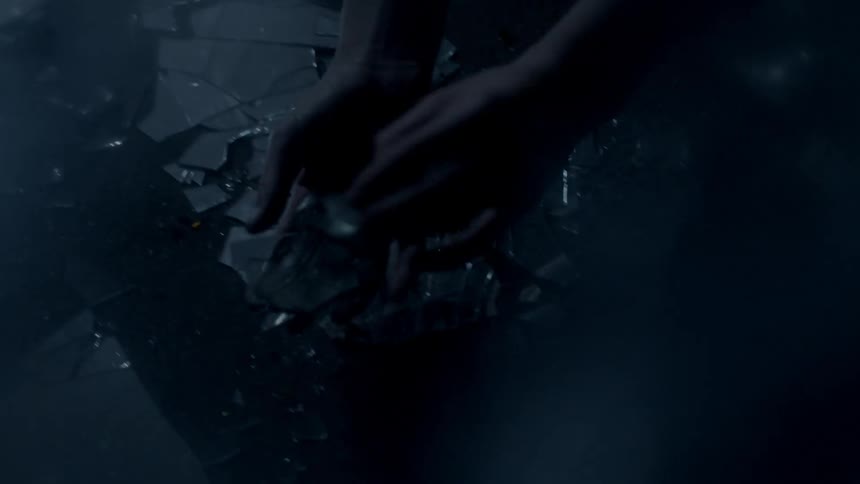 A person is frantically picking up glass on the ground