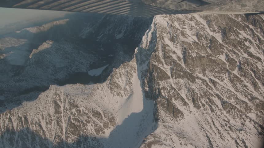Snow covered mountains stand tall together in the landscape