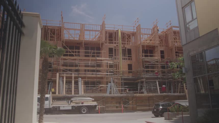 Cars are driving by a construction site during the day time