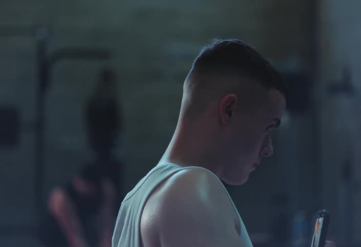 A man films with his cell phone in the gym