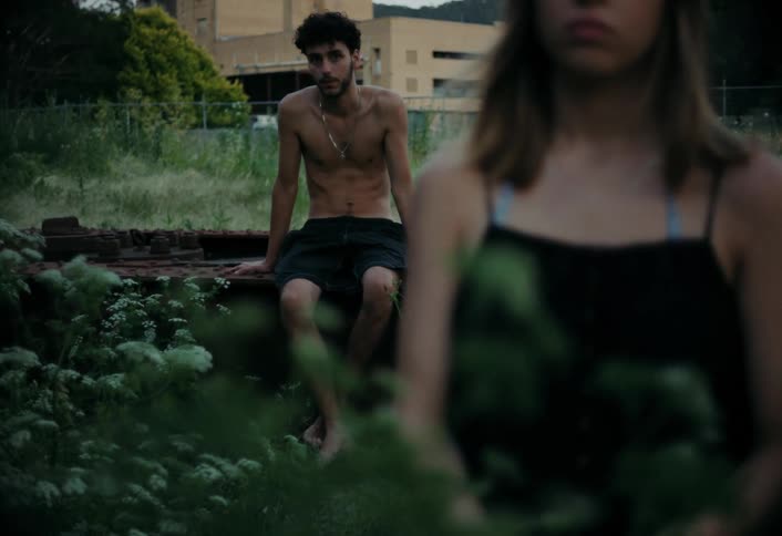 A teenager is watching a girl in the lot