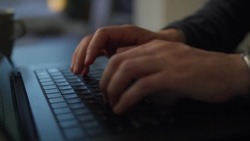 While sitting down a person is typing on their laptop