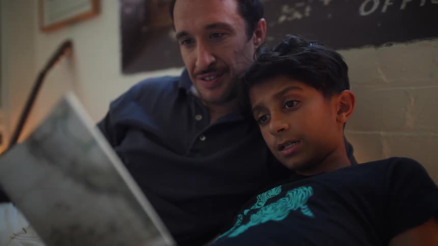 A footage of a father and son reading together