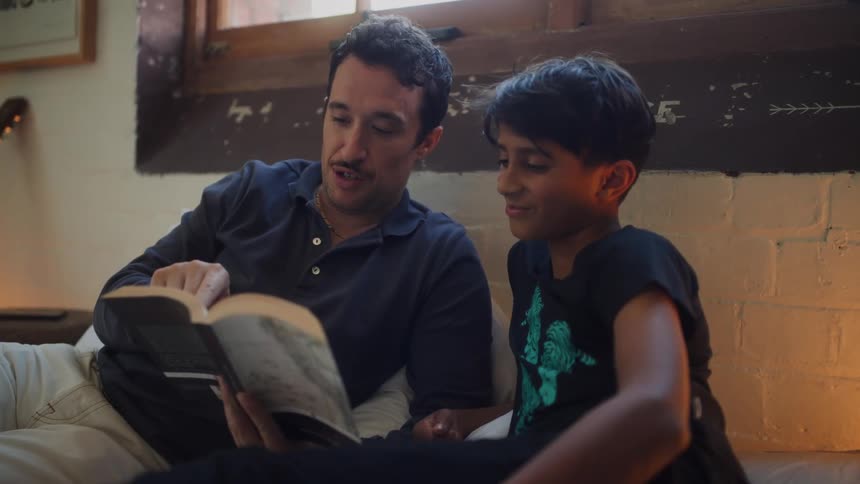 A father is reading a book to his son