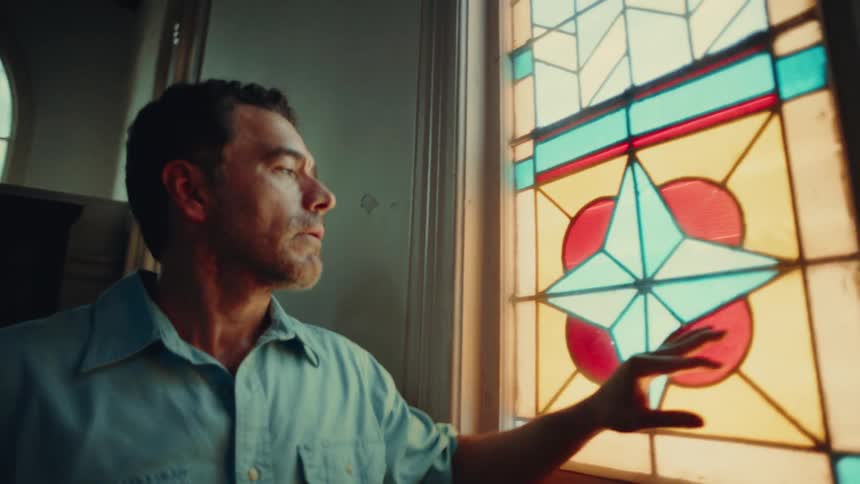A footage of a man standing by a window
