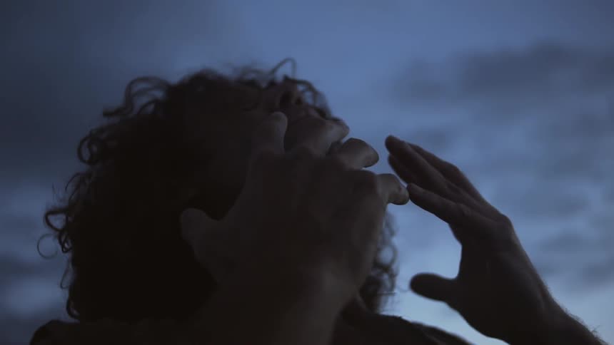 A man touching his face as he is outside