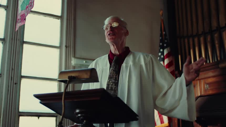 A footage of a man speaking on a podium