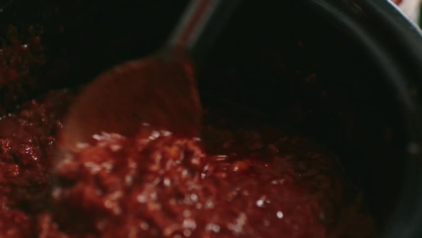A footage of a person stirring a stew
