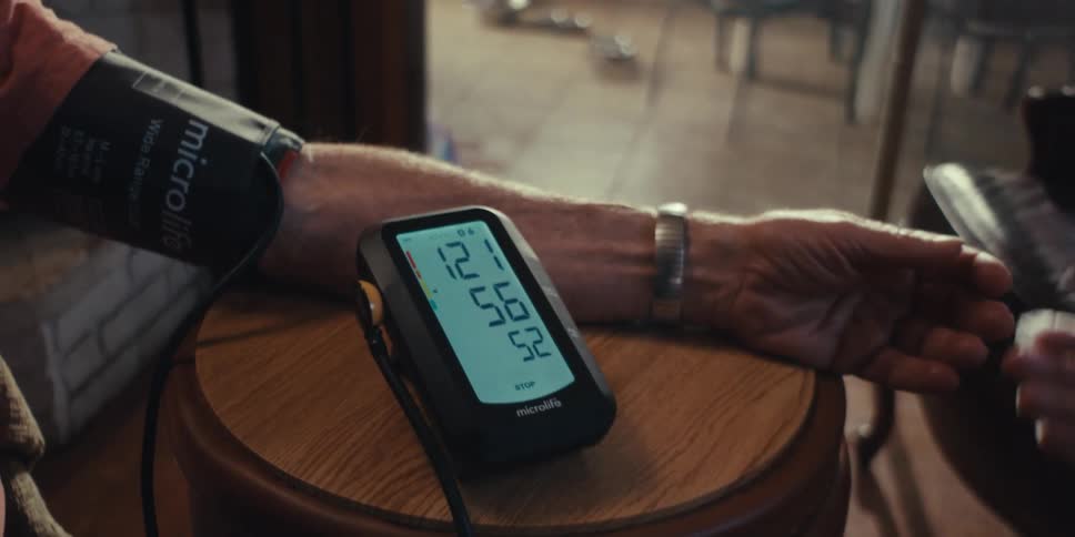 Elderly persons arm being measured by a blood pressure monitor