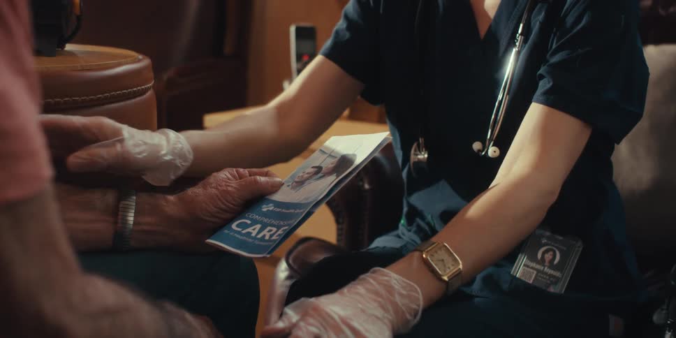 Female medical professional talks to an elderly patient about elder care