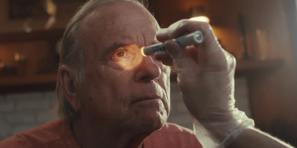A man is having his eyes checked with a flashlight