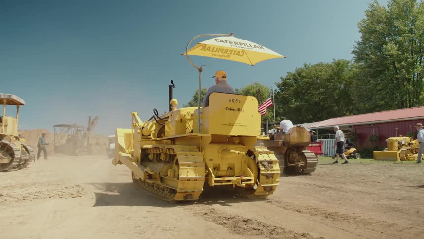 A yellow bulldozer is driving on the work site