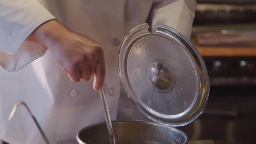 A chef stirs a pot