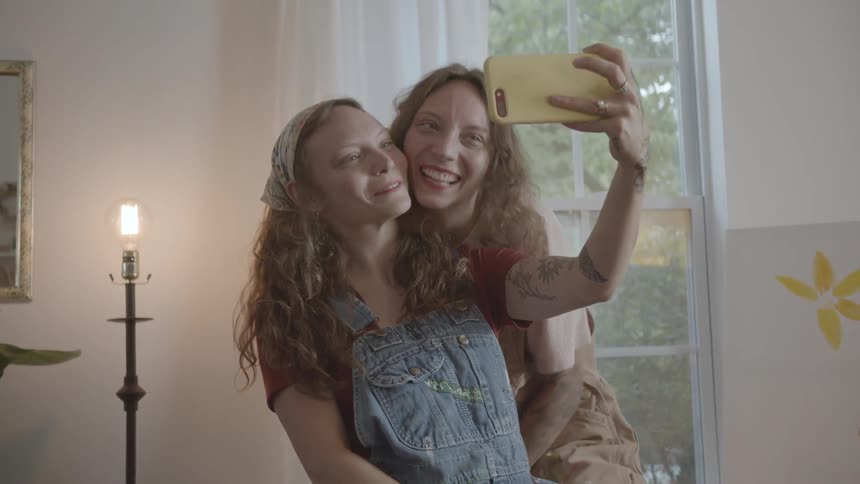 Two women take a selfie by the window