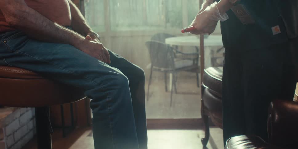 Female medical professional gives an elderly male patient a physical exam during a home healthcare visit