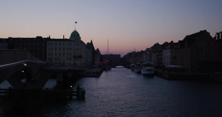 Boats are docked by the apartment buildings in the city