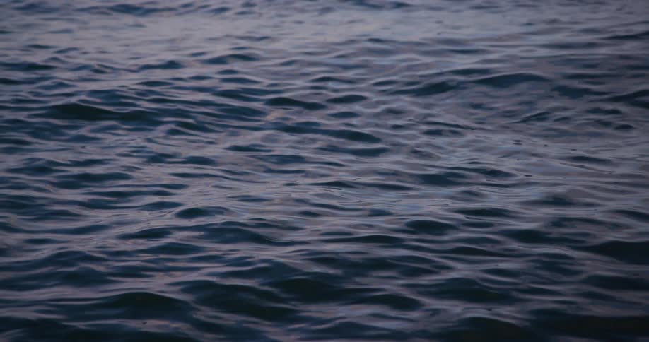 Rippling water reflects varying shades of blue with subtle highlights from the sky above
