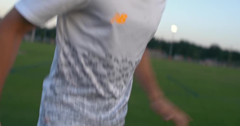 A man is kicking a soccer ball on green grass