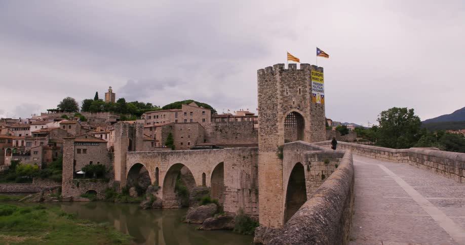 A stone bridge leads to the village