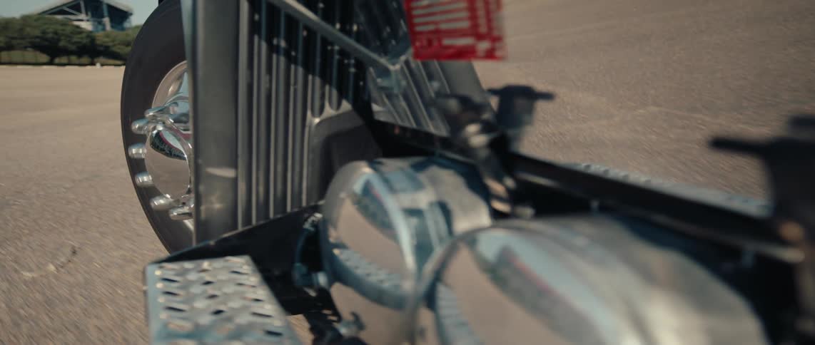 A large truck is driving in an empty parking lot