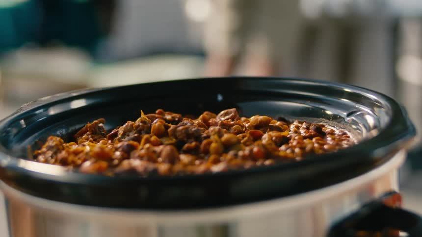 Chili is being cooked in a crock pot at someones home