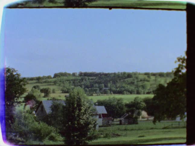 The valley ahead has some houses and trees all over