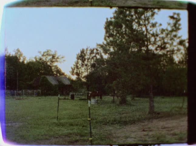 A barn is in the distance of this field on a clear day
