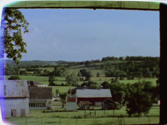 Cars drive on a rural road in the distance