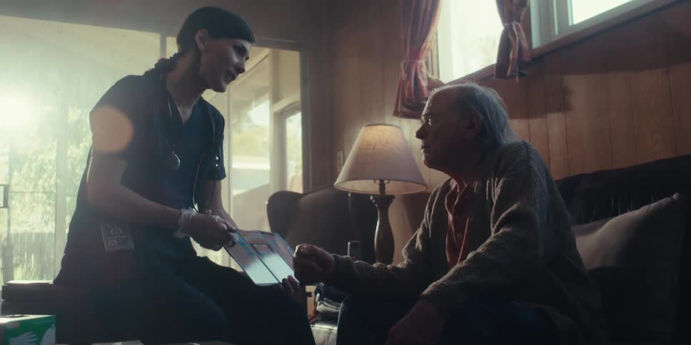 A footage of a female doctor making an illustration to an elderly man indoor