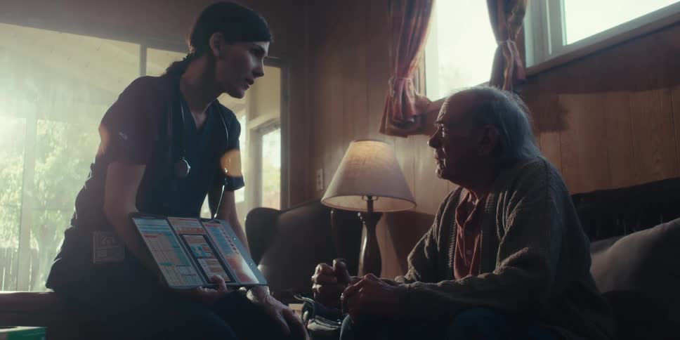 Young nurse sitting across from an elderly man talking to each other