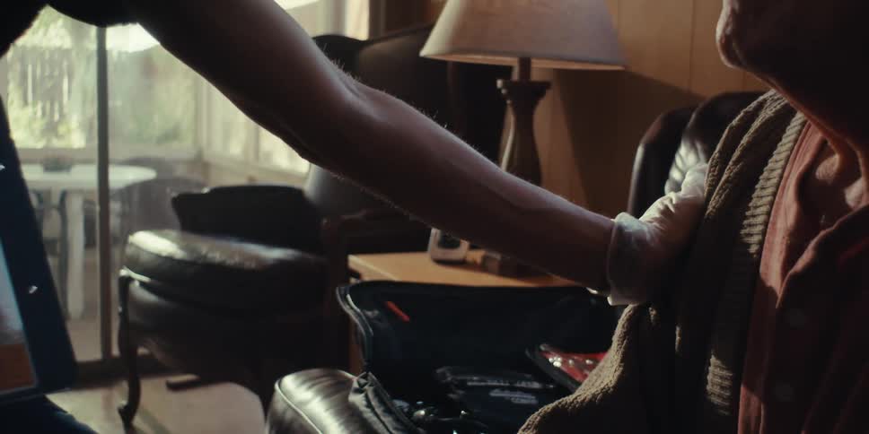 Hands of a nurse with gloves talking to an elderly man