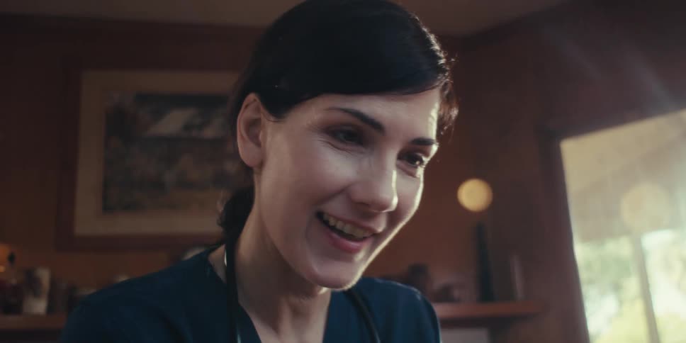A woman smiles as she is talking
