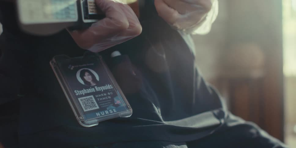 A doctor is sitting in her office and wearing a badge