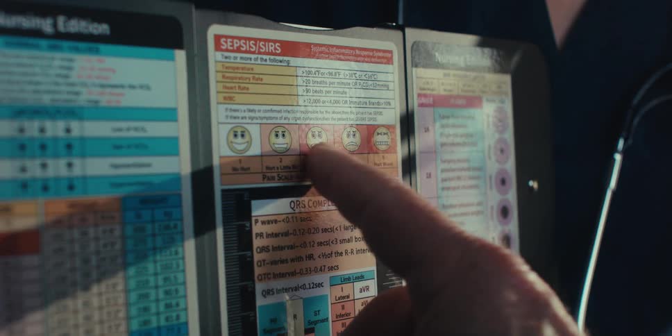 A closeup of a doctor holding a medical chart as a patient points to it with their finger