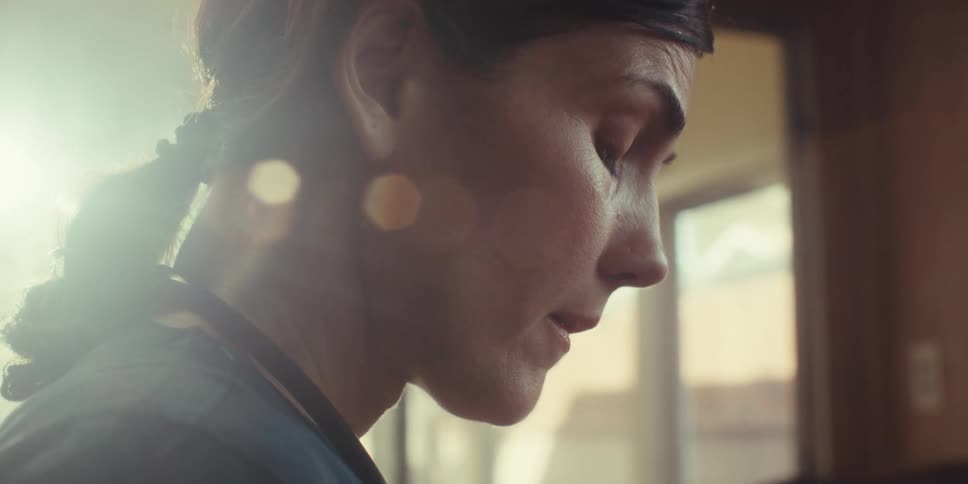 Female medical professional looks upset while standing inside a home on a sunny day