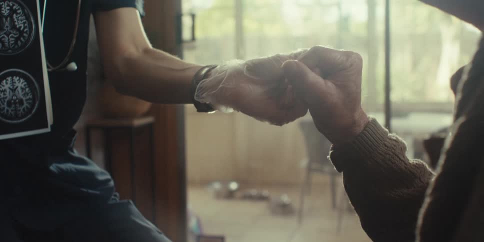 A nurse holds a patients hand
