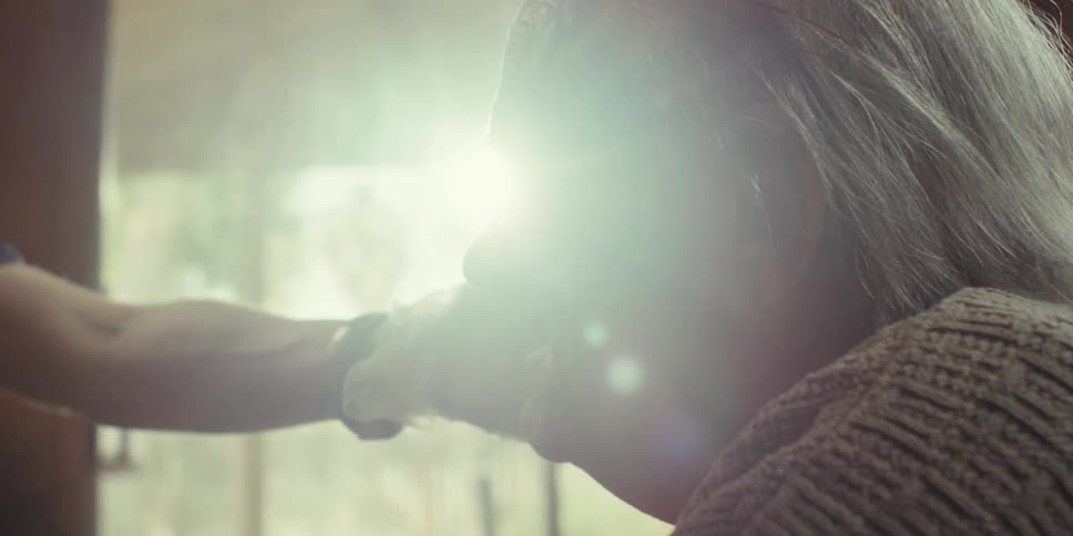 A nurse touches a patients face