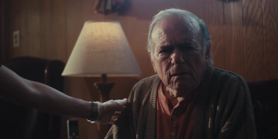 Home healthcare professional comforts an elderly patient upset by the news he is receiving