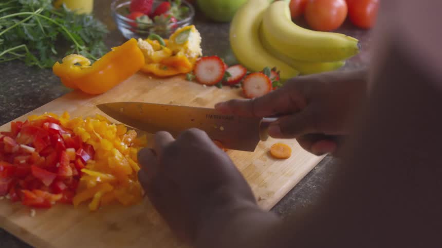 Slicing bell peppers with a sharp chef knife on a cutting board