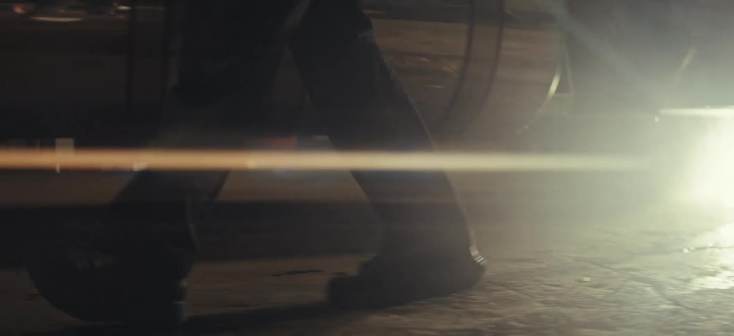 A man is walking past his parked vehicle during the night time