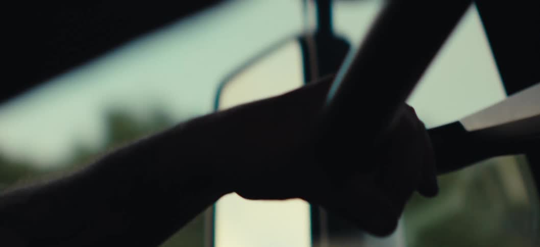 Closeup of a persons hands handling a steering wheel of a moving vehicle