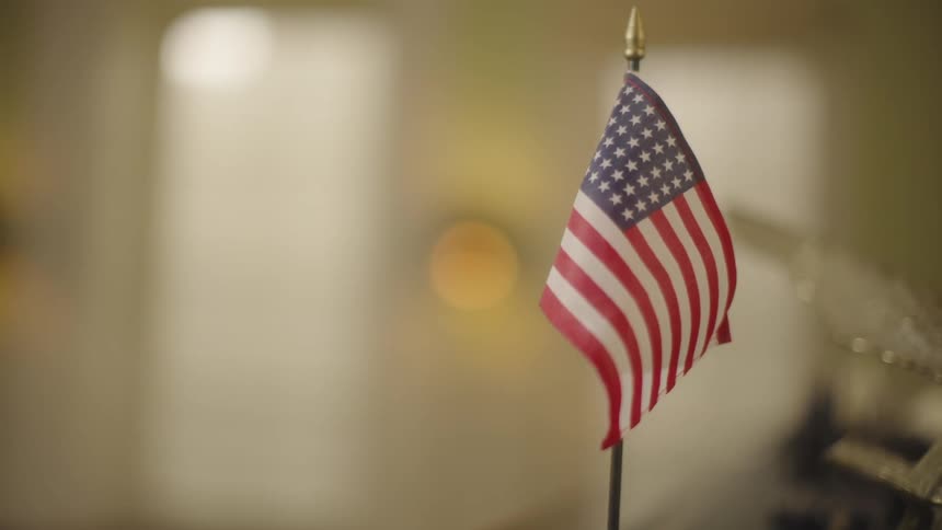 Small american flag stands near the other decorative elements in a room