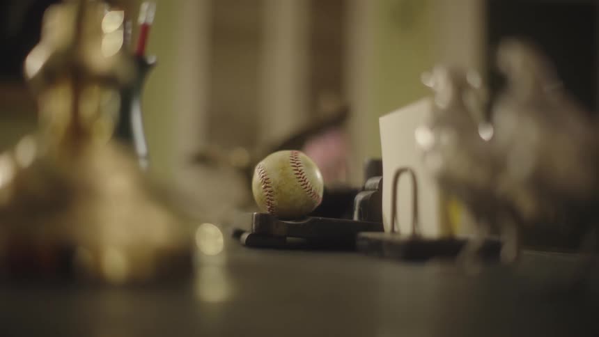 Baseball on top of a wooden table with other instruments