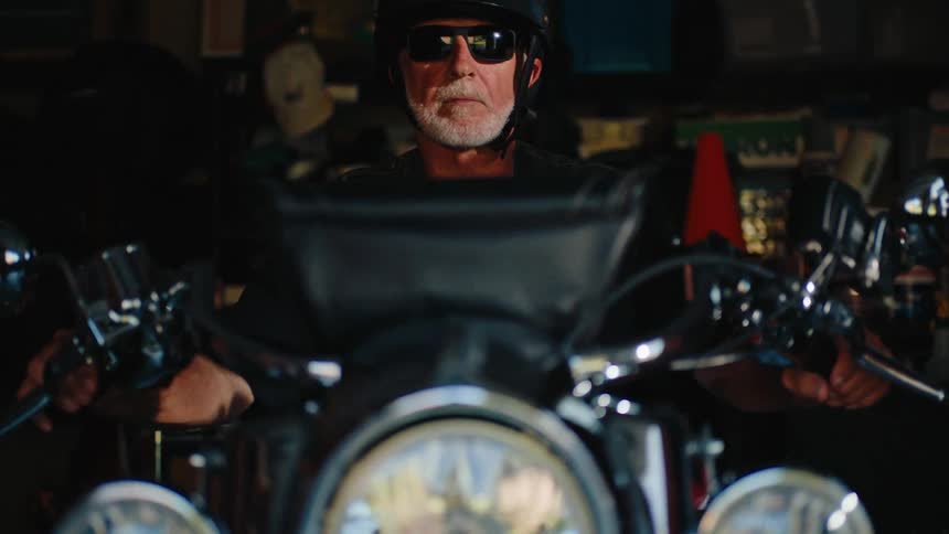 A man gets on his motorcycle and starts it