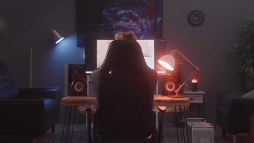 Gamer sits in front of a large screen and plays a video game