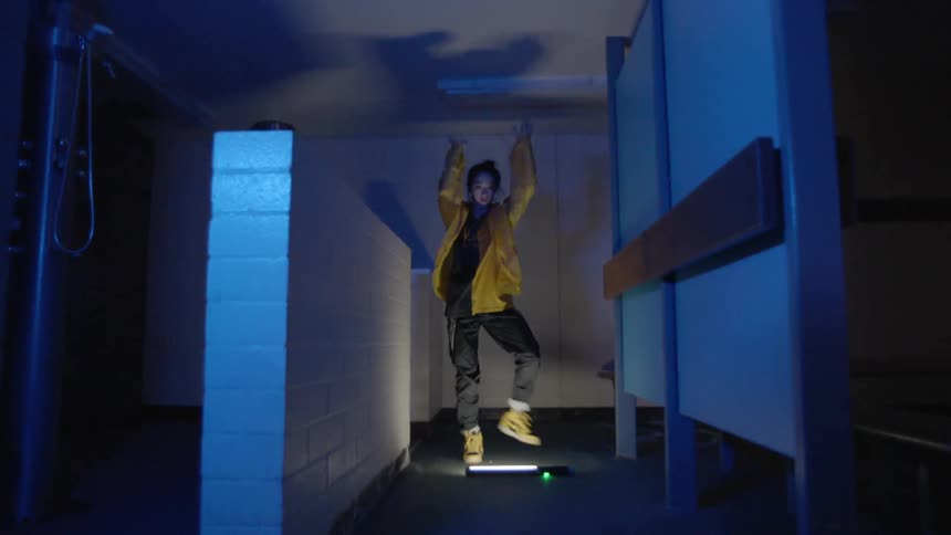 A woman is dancing in a dark hall