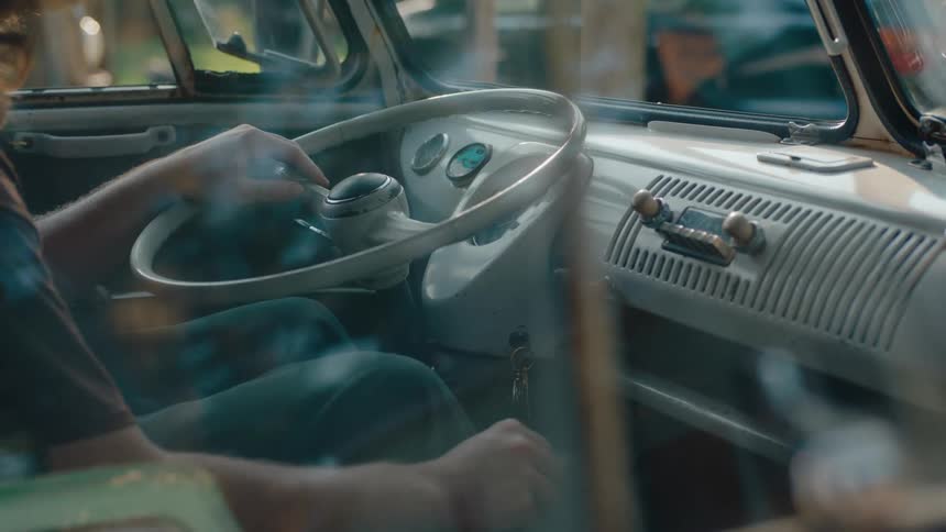 Person at the wheel of an old vehicle shifting gears